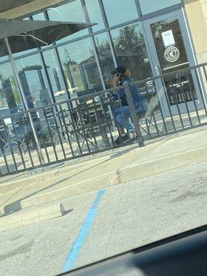 The worker eating as the doors are closed and customers are outside waiting.