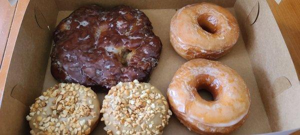 Apple fritter, glazed donuts and peanuts with maple glazed.