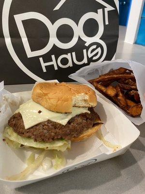 Impossible Cheeseburger with Sweet Potato Fries. The bun was torn and looked like some one had already taken a bite.