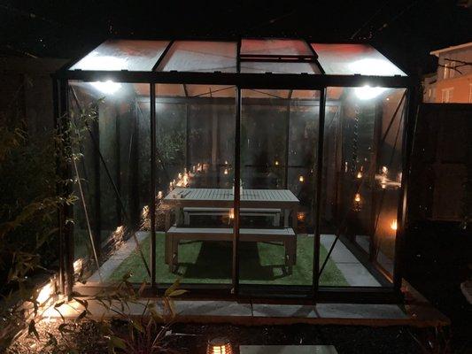 Closeup of greenhouse with lights at night.