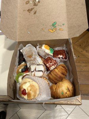 Pastries overstuffed into box, upside down cakes, cannolis now covered in frosting. Not going on my Christmas table. Not cool.