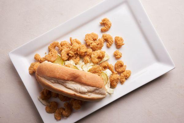 Shrimp po-boy, consists of onions, tomatoes, pickles, and lettuce