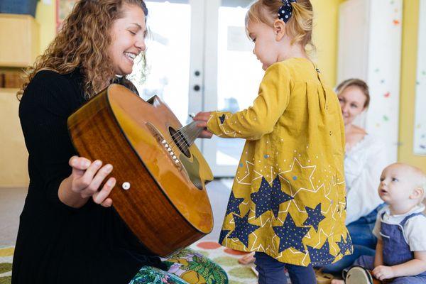 Alex A. teaching children about the guitar.