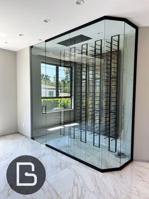 Modern wine cellar featuring 1/2" clear tempered glass panels and black hardware for a frameless, elegant look.