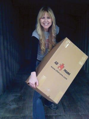 Founding partner Kristin Stancato helps to offload the final box of a new shipment of djembes.