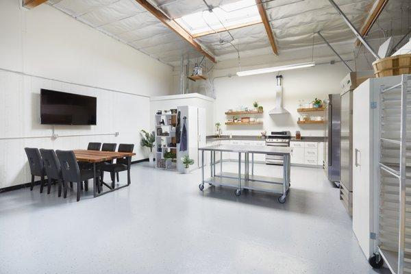 Client table with large screen TV and custom kitchen