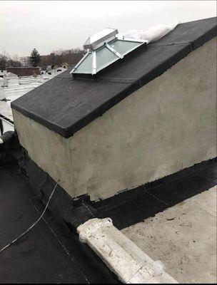 New layer of APP 160 Firestone rubber roof being installed  over the bulkhead and and new skylight