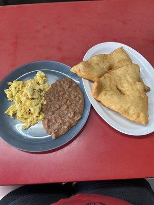 Eggs with stew beans, and fry jacks.