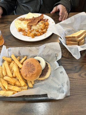 Breakfast plate with eggs, bacon, home fries.  Hamburger with fries.