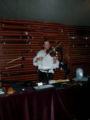 Taking a break between customers, the Captain pulls out his strings and amuses himself at one of our Renfair setups.