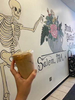 Iced blackberry thyme latte with adorable mural inside