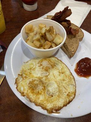 Two egg breakfast over medium with hash browns and bacon