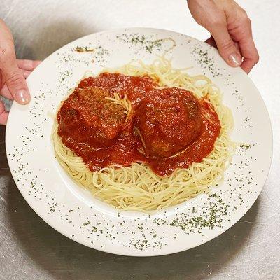 Giant meatballs in marinara sauce over pasta.