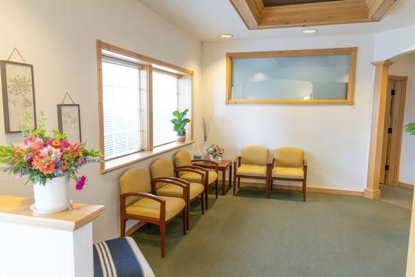 A tranquil waiting room where your comfort comes first, complete with warm touches of nature.