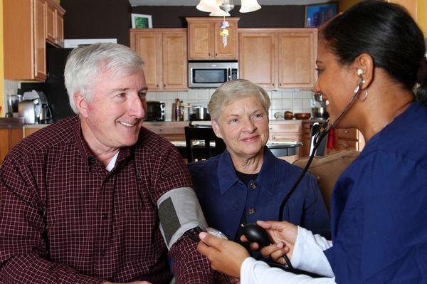 Caregiver checking blood pressure of a resident