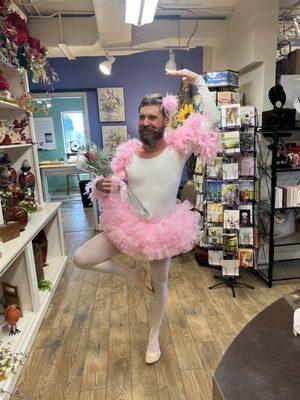 Mitch Allen in a pink tutu, feather boa, and frilly bottom tights posing in public