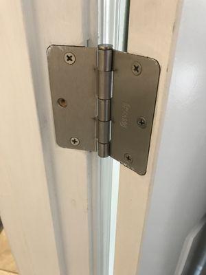 Another door with missing hinge screws.