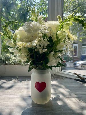 White roses, daisies, baby's breath, snapdragons, ferns and greenery.