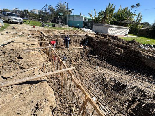 Guys digging rebar out of mud after flood with their hands