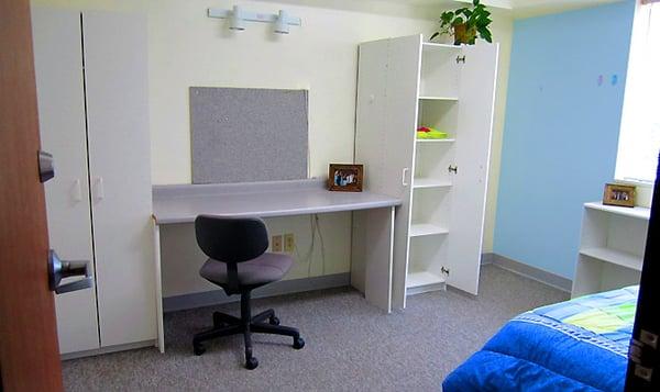 A bedroom within a three-bedroom apartment.