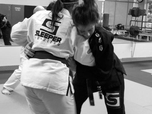 Students practicing takedowns in BJJ basics class.