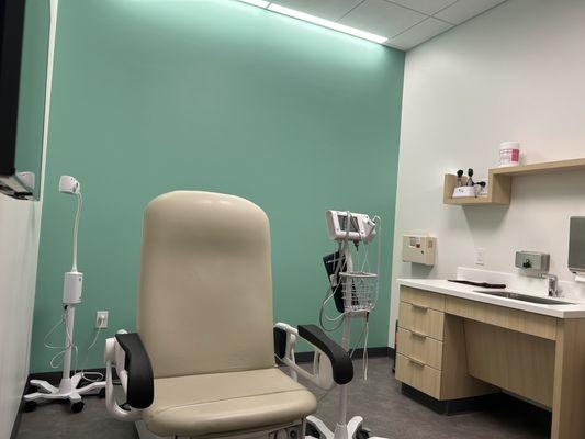 Very clean exam room with calming colored accent wall.