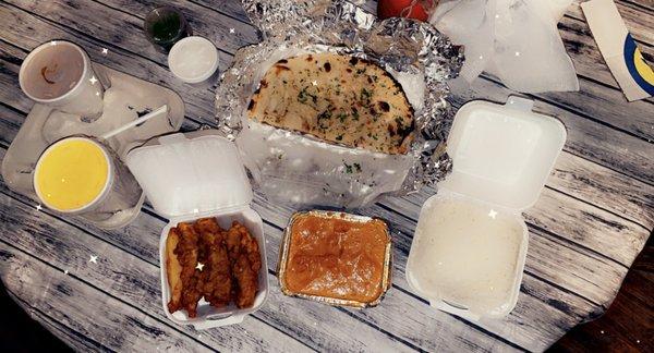 Lamb makhani, chicken pakora, basmati rice, garlic naan, mango lassi, and chai. Chef's kiss to this delicious spread!