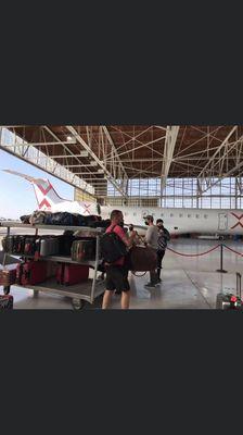 Bag cart and plane in hanger