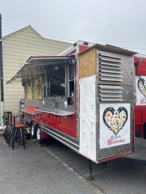 Outside of food truck, showing 5-6 barstools