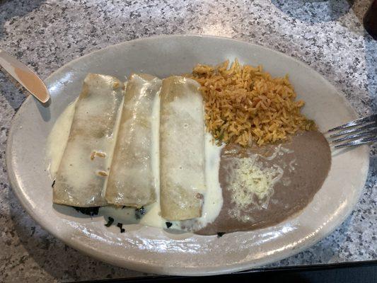 spinach enchiladas with sides of refried beans and rice