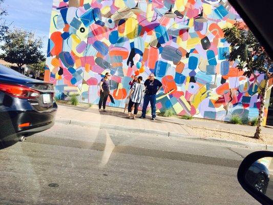 Photographer taking pictures by a mural outside of Zinburger in downtown Gilbert