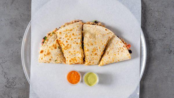 A warm, grilled tortilla filled with melted cheese, savory meats, and fresh veggies. A crispy, cheesy bite of Mexican bliss!