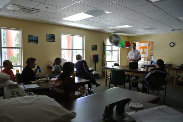 Dr. Tron Malachowski presenting to Laura Christiansen & her team at Sports Plus Therapy on the benefits of Specific Chiropractic