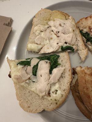 A Chicken Pesto sandwich that is supposed to contain:   Grilled chicken, tomato, arugula, pesto* aioli, house vinaigrette, baguette