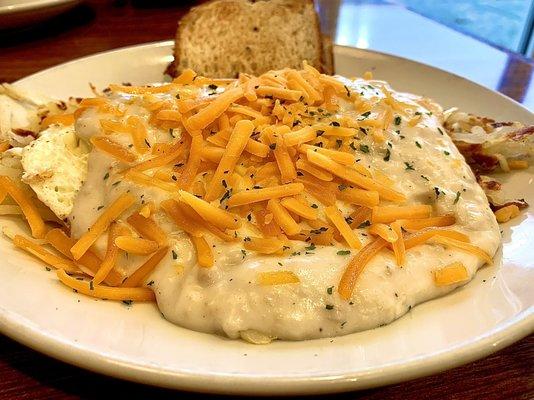 Hash brown topped with over easy eggs and sausage gravy