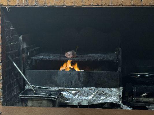 Chateaubriand cooking over an open fire.