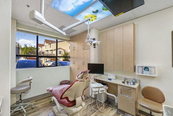 Dental exam room with chair and TV for patient comfort, with lots of natural light in Fremont, CA