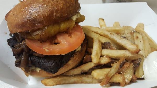 Crazy Jamaican Burger with plantains, tofu, potato salad, grilled onions, tomatoes, and aioli with a side of fries.