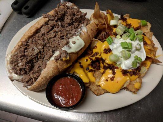 Leather Corner Post Cheesesteak- marinara, onions, american cheese, banana peppers. Side is homemade loaded chips