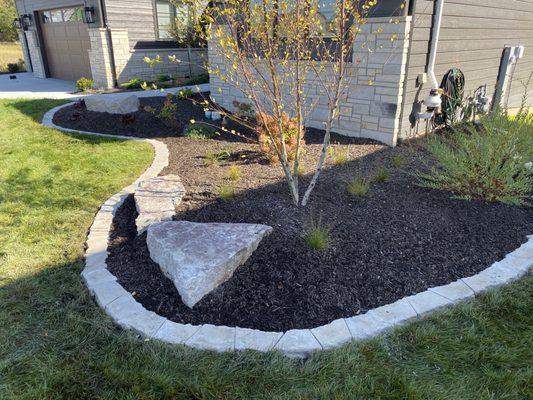 Wedge stone installation around the garden bed boarder