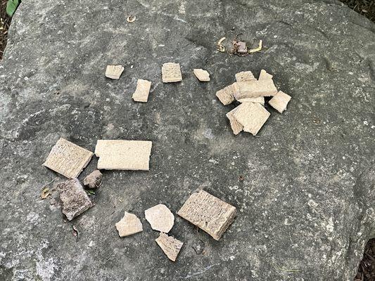 Cracked brick pieces on ground beneath chimney