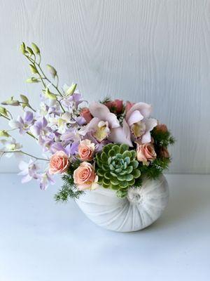 Gorgeous shell shaped ceramic container with orchid , succulent,spray rose and fresh green.