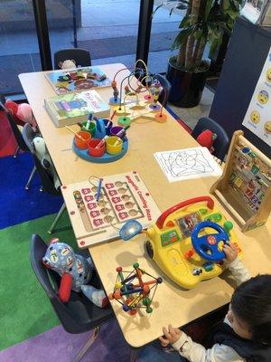 Table of activities for children. The bear on the chair is handmade and donated by someone. Every child can take ONE bear home with them