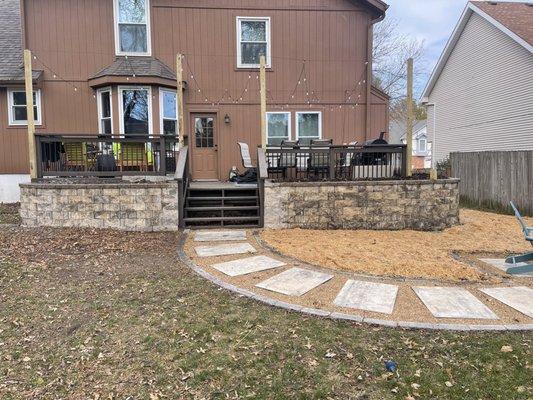 After raised stone plant bed installation around deck and installed deck hanging lights