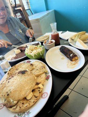 Plate of papusas, plantain, corn tamales, curtido, salsas, Mom with her breakfast plate of steak, eggs, beans, and plantain with tortillas