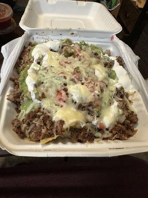 Super Carnitas Nachos with melted cheese and sour cream. Yum!