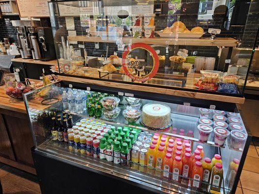 Cooler case with water, jombucha and juices with croissants in glass display