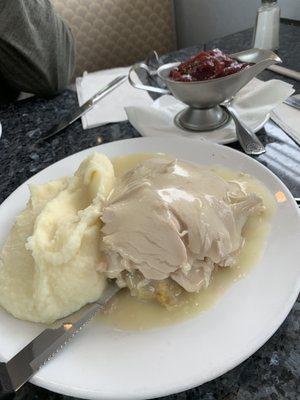 Hot turkey lunch, stuffing made with potato bread. A boat of cranberry sauce. Tender moist real turkey.