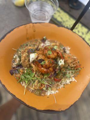 Fried catfish on a bed of white rice with seafood gravy topped with two large shrimps.