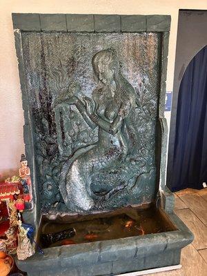 Indoor fountain with live goldfish at base.